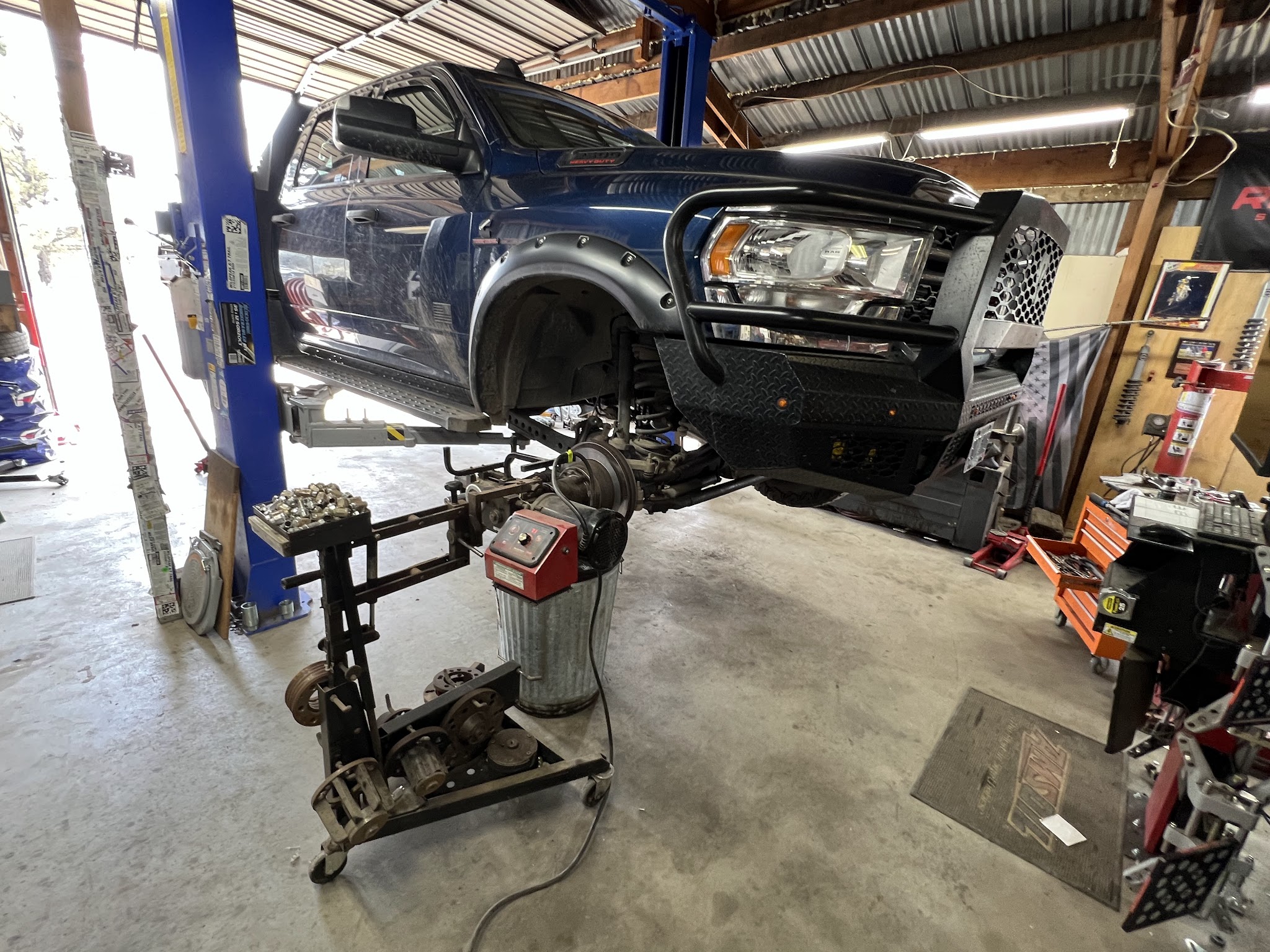 A heavy duty Ram truck raised on the lift with alignment equipment underneath