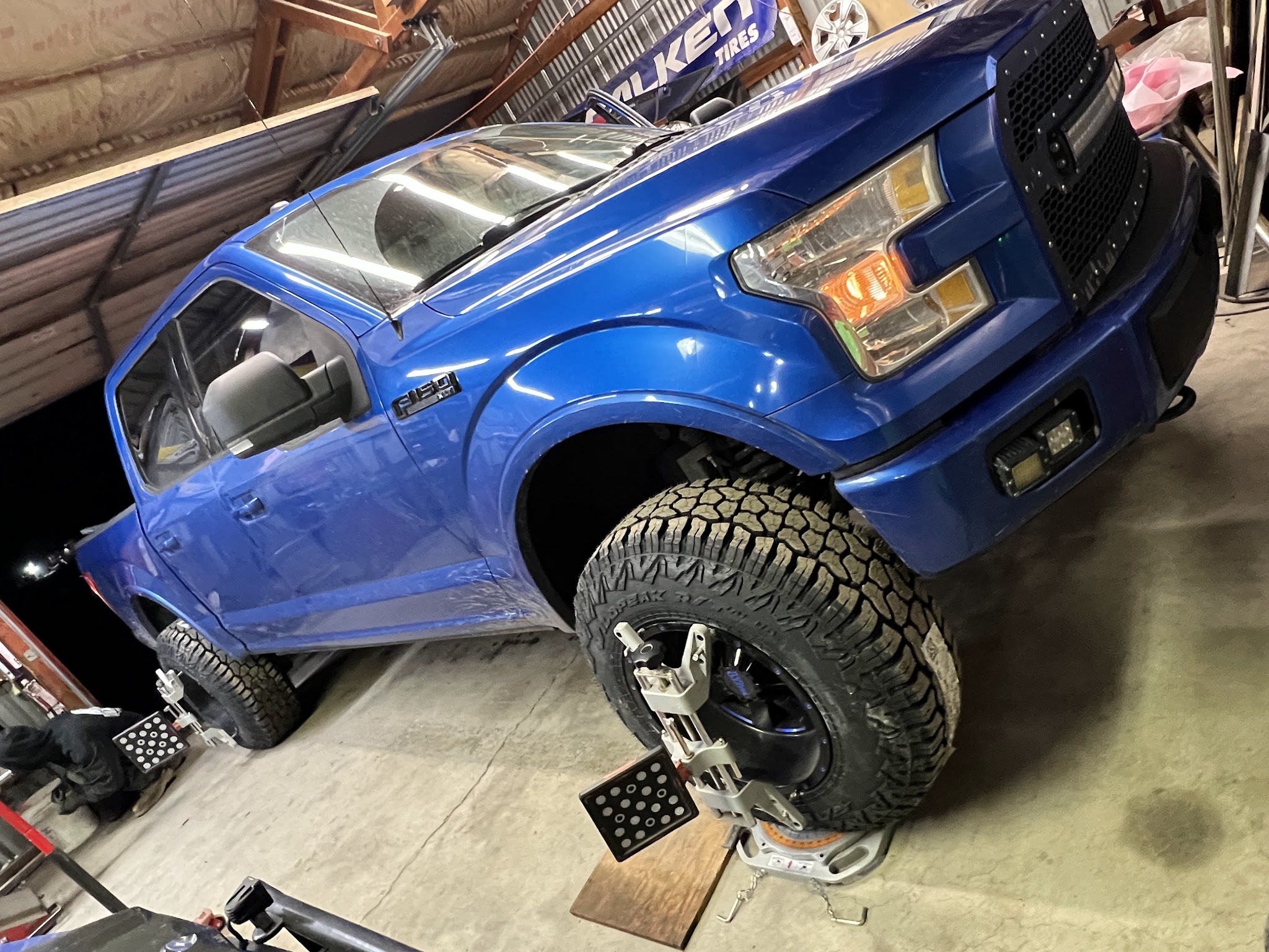 A Ford F-150 sitting on the alignment rack with targets fitted to the wheels
